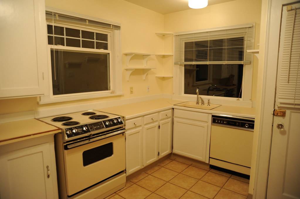 Rental house kitchen, yellow walls, yellow fixtures and appliances, yellow tile floor, night, Green Lake / Phinney Ridge, Seattle, Washington, USA